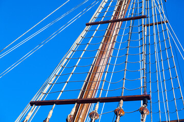 Mast with ropes and ladder on an old wooden ship, bottom view.
