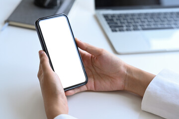 Close up view businesswoman hands holding mobile phone. Empty screen for graphics display montage.