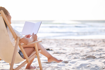 Nothing like the ocean and a good book. Shot of an unrecognizable woman reading a book at the beach.