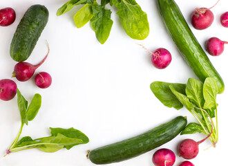 Preparation of spring salad from cucumber, radish and spinach. Salad ingredients on a white background. A place for text. View from above. concept