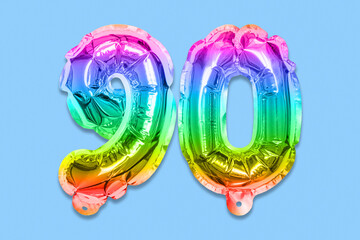 Rainbow foil balloon number, digit ninety on a blue background. Birthday greeting card with...