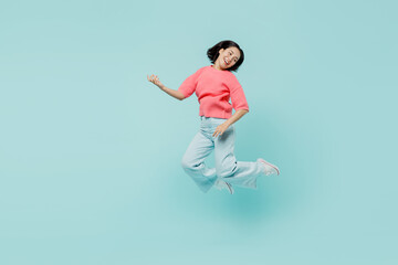 Fototapeta na wymiar Full body young smiling singer happy woman of Asian ethnicity 20s in pink sweater jump high paly guitar isolated on pastel plain light blue color background studio portrait. People lifestyle concept.