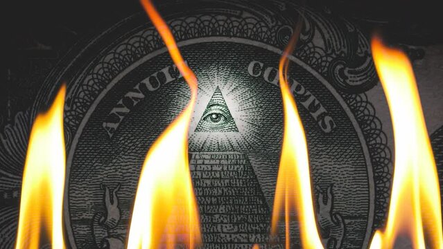 Pyramid on a banknote of 1 US dollars bill with glowing freemasons eye on top on fire in flames. Conceptual 4k slow motion raw video. Financial crisis idea, conspiracy theory.