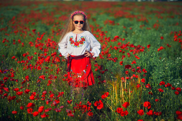 A little girl in a Ukrainian vyshyvanka in a poppy field