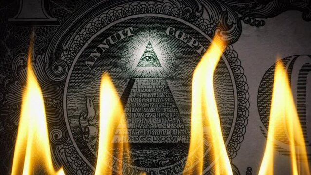 Pyramid on a banknote of 1 US dollars bill with glowing freemasons eye on top on fire in flames. Conceptual 4k slow motion raw video. Financial crisis idea, conspiracy theory.