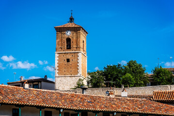 Fototapeta na wymiar View of Clock Tower of Chinchon in Madrid. Low angle view agaisnt sky. Old Our Lady of Grace church
