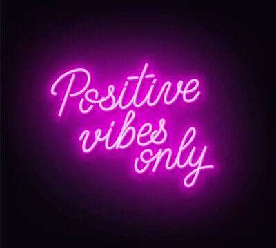 Positive Vibes Only neon lettering on dark background.