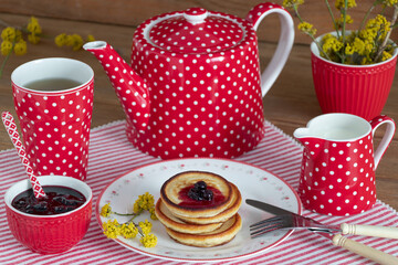 Pfannkuchen mit Johannisbeer-Konfitüre und rotes Teegeschirr