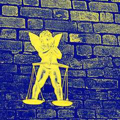 żółty anioł na tle niebieskiego ceglanego muru jako symbol zwycięstwa Ukrainy - obrazy, fototapety, plakaty