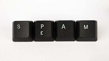 Spam text created with keyboard keys isolated on white background, white spam letters on black keyboard, top view