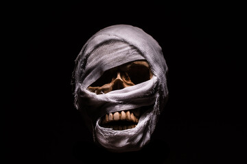The artificial skull is wrapped in a cloth. Mummy