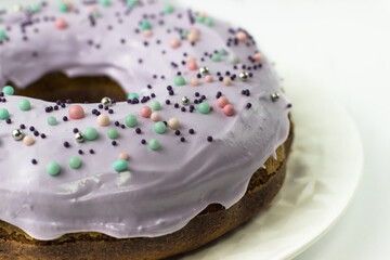 Cake with lavender-colored glaze on a white background