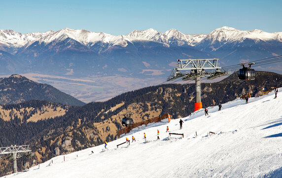 Winter ski resort Jasna with modern cable car funitel, skiers and panoramic mountain scenery in Low Tatras, Slovakia