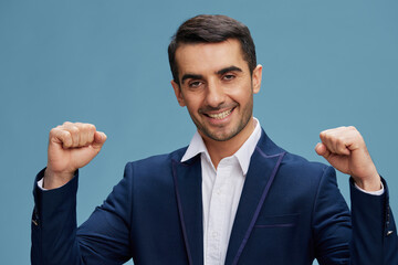 smiling successful man in business blue suit businessman holding blocks in front of him boss on blue background Copy space