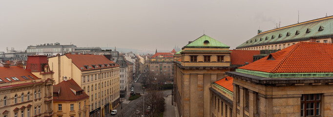 Fototapeta na wymiar Cityscape of Prague city center. A morning view of a street in the center of Prague with the Ministry of Transports and on the background Prague Castle in the fog.