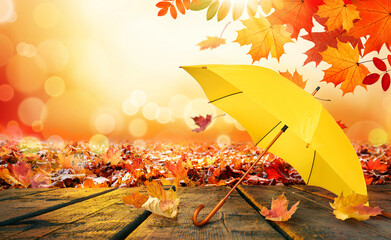Autumn background with yellow umbrella on wooden deck