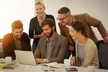 Going over some of the new designs. Cropped shot of a group of businesspeople looking at a laptop in the boardroom.
