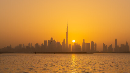 Orange sunset behind the Dubai skyline