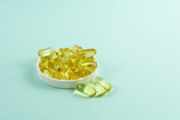 Capsules with fish oil on the lid close-up on a colored background. Vitamin complex omega 3,6,9.