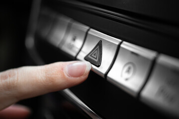 Car emergency light button, triangle car warning button in luxury sport car closeup