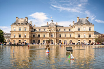 Fototapeta na wymiar Parisians and tourists having relax at pond next to Luxembourg Palace in Paris. Palace was built in 1615–1645 to be royal residence of the regent Marie de Médicis, mother of Lou