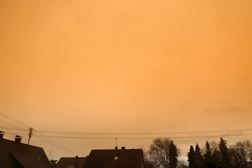 Eine Wolke aus Saharastaub Saharasand verfärbt den Himmel gelb über den Dächern von Meitingen im...