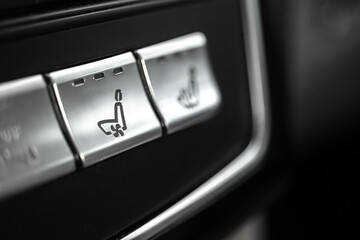 Naklejka premium Heated seats buttons inside car. Seat heating buttons control panel in luxury car close-up view photo