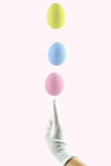 Three colored Easter eggs levitate above a human finger. Easter egg balance.