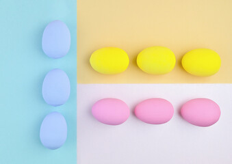 Blue, yellow and pink Easter eggs on a colorful background. Geometric Easter composition.