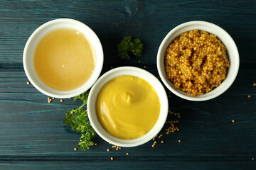 Bowls with sauces on wooden table, top view