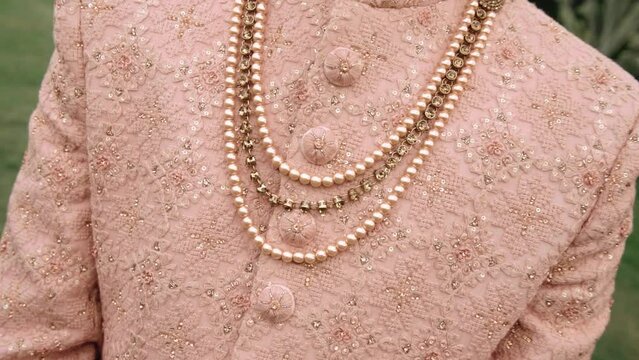 groom wearing sherwani and pearl jewellery on wedding day, fashionable wedding dress for men, tradional indian wear | selective focused