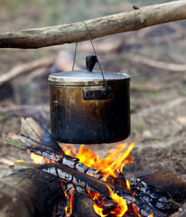Cooking in sooty cauldron on campfire