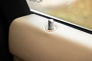 Automatic door locks, car door lock button pin inside luxury car close-up view