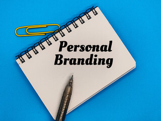 Paper clips, notebooks and pens with the concept of the word Personal Branding.