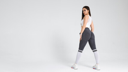 Portrait of a young athletic woman in sportswear in the studio on a white background