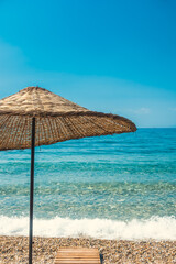Summer and holiday background with sea, beach and umbrella. Dilek Peninsula National Park near Kusadasi, Turkey.