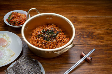 Korean traditional Ramyeon noodle in a traditional korean noodle pot, Spicy Korean Ramyeon instant noodle a traditional dish.