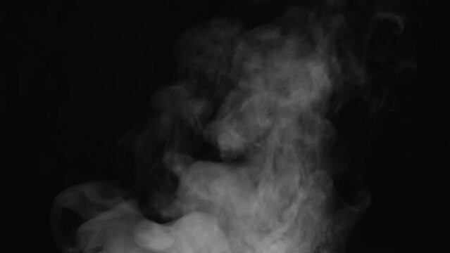 Intense Steam from the Pan. White Steam rises from a large pot that is behind the scenes. Black background. Filmed at a speed of 120fps