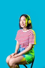 Young asiatic woman wearing headphones listening music