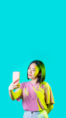 Young asiatic woman isolated using smartphone taking selfie