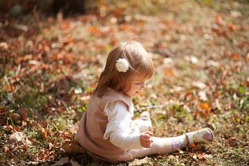 Little beautiful girl portrait in autumn street. Happy smart small girl in autumn park