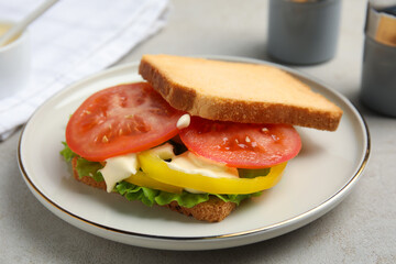Delicious sandwich with vegetables and mayonnaise on grey table, closeup
