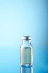 Vaccine injectable vials and syringe close up in blue tones