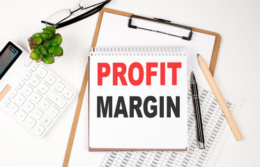 Office desk table with paper sheet, notepad ,chart and calculator. Top view, text PROFIT MARGIN
