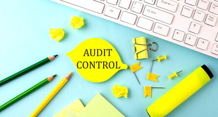 Text sign showing AUDIT CONTROL with office tools and keyboard on blue background