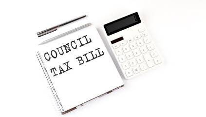 Notepad with text COUNCIL TAX BILL with calculator and pen. White background. Business concept