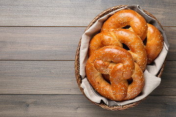Basket with delicious pretzels on wooden table, top view. Space for text