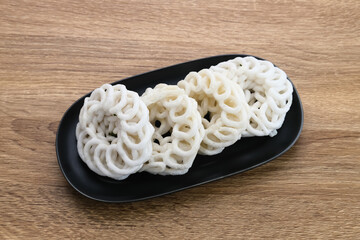 Krupuk or Kerupuk, Indonesia traditional crackers, served on black plate on wooden background.
