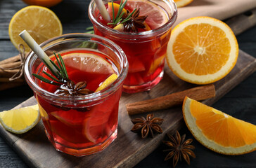 Aromatic punch drink and ingredients on black wooden table