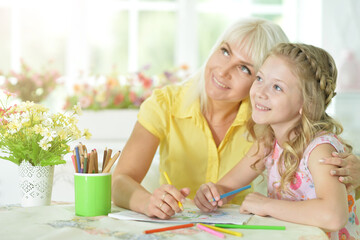 Beautiful mother and daughter drawing